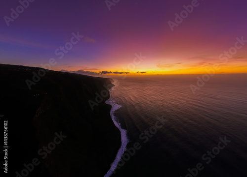 Obraz na płótnie Golden hues paint the horizon as the sun sets over a tranquil ocean and rugged coastline w salonie