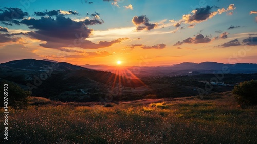 Mountains Field Sun Sky Clouds Orange Horizon Landscape. Bright sun rays over dark hills at sundown. Colorful sky and nature scenic.