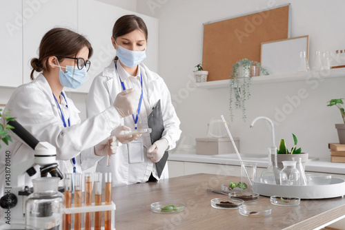 Female scientists working with Petri dish in laboratory