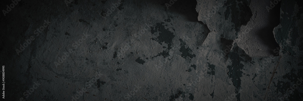 Dark wide panoramic background. Peeling paint on a concrete wall. Dark grunge texture of old cracked flaking paint. Weathered rough painted surface. Patterns of cracks. Darkness background for design.