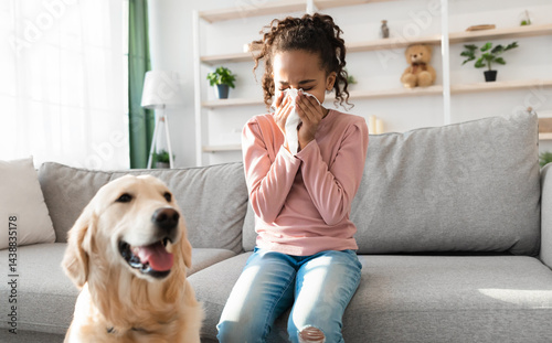 Allergic Reaction To Fur. Sick black girl sneezing and sniffle holding paper tissue. Ill kid having rhinitis suffering from running nose caused by her pet dog, sitting on sofa at home, free space