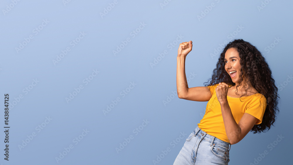 Euphoric brunette woman emotionally celebrating success, raising fists and exclaiming with excitement, lucky young lady yelling with joy, standing over purple background in studio, panorama Euphoric brunette woman emotionally celebrating success, raising fists and exclaiming with excitement, lucky young lady yelling with joy, standing over purple background in studio, panorama