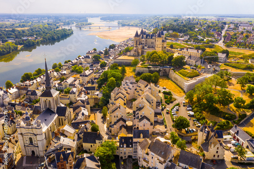 Fototapeta Naklejka Na Ścianę i Meble -  Scenic aerial view of Saumur town on banks of Loire in western France overlooking ancient castle and parish church in summer..