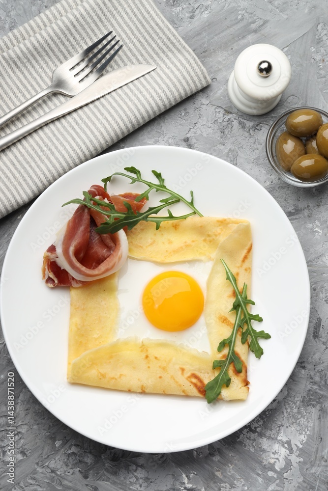 Delicious crepe bretonne with bacon and arugula served on grey textured table, flat lay Delicious crepe bretonne with bacon and arugula served on grey textured table, flat lay