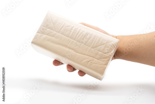 Obraz na płótnie Hand holding Brown tissue paper pack isolated on white background. w salonie