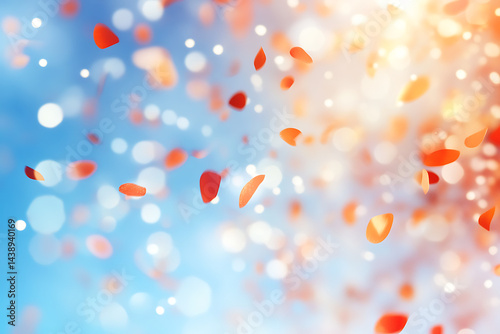 Confetti falling in the sky, blue background, red and orange small dots, blurred. photo