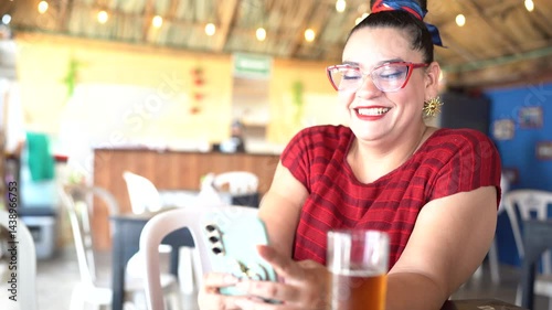 Smiling businesswoman using mobile phone in a palapa restaurant in Mexico