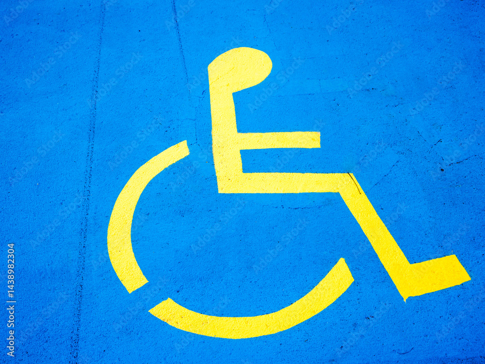 Bright yellow person in wheelchair graphic on blue background noting disabled car park