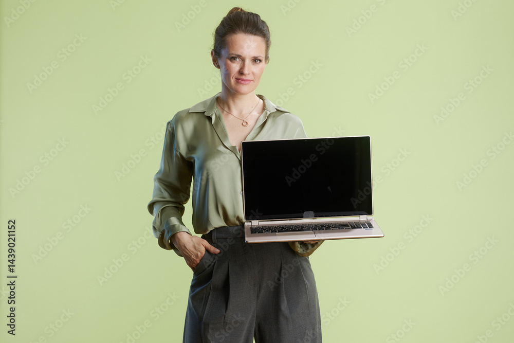 Confident businesswoman holding laptop