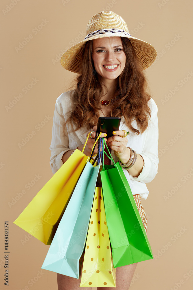 happy stylish woman in blouse and shorts isolated on beige