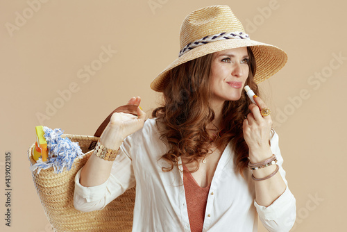 smiling elegant female in blouse and shorts on beige