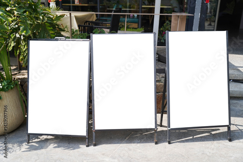 Obraz na płótnie Three blank white outdoor advertising stand or sandwich boards mock up template placed by an outdoor dinning area of a restaurant. w salonie