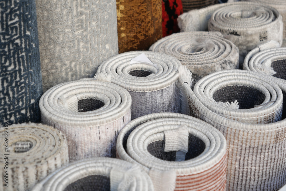 Obraz premium Various rolled rugs displayed in a market for sale