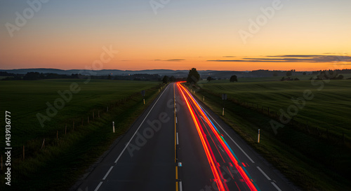 Highway At Dusk With Car Trails Heading Into The Distance