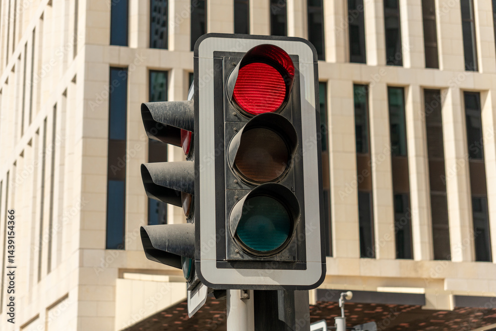 a city crossing with a semaphore on blurred background with cars in the evening streets, red light