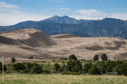 Fototapeta Naklejka Na Ścianę i Meble -  Desert landscape with sand dunes and mountains under a clear blue sky during daytime