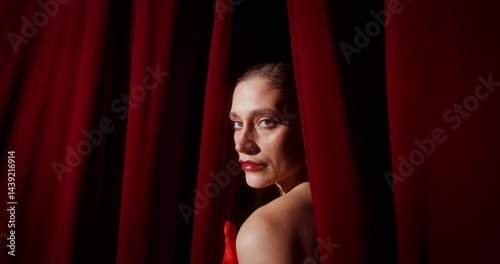 The stylish actress looks at the camera from behind the scenes. She stands on the stage of the theater photo