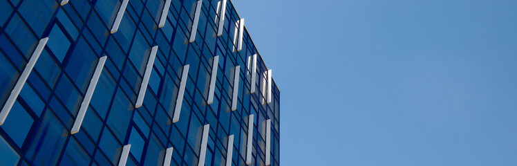 Contemporary glass facade of blue office building with geometric grid pattern, modern corporate architecture background for business and finance