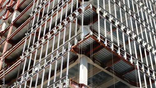 Construction site showing modern building framework with exposed steel beams, metal support structures and industrial scaffolding