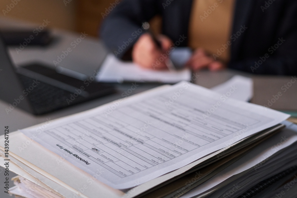 Obraz premium Focus on stack of psychological paper documents standing on workplace of modern school psychologist taking notes on background
