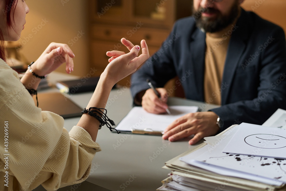 Hands of troubled teenage schoolgirl sharing her problems with psychotherapist during communication at session