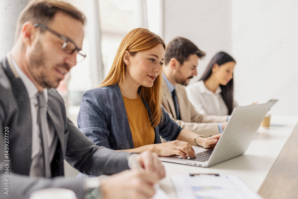 Leadership team with laptop and paperwork collaborating on a project at boardroom in corporate firm. Leadership team with laptop and paperwork collaborating on a project at boardroom in corporate firm.