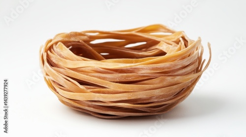 Obraz na płótnie Uncooked brown tagliatelle pasta nest isolated on a clean, white background. It's ideal for illustrating Italian cuisine or healthy eating concepts. w salonie