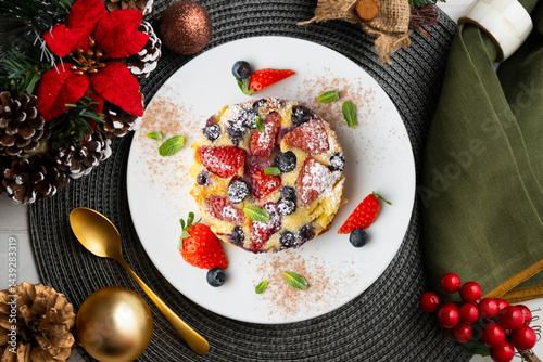 French clafoutis tart with red berries. Top view with christmas decorations. photo