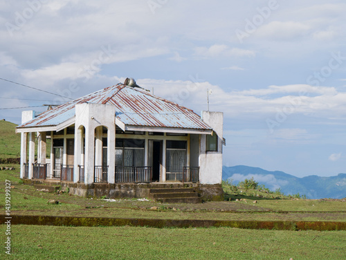 old damaged and collapsed house building on green hills photo