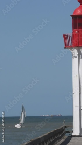 Classic sea landscape with a bright lighthouse and a sailing yacht. Space for advertising and text photo