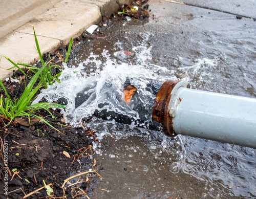 A water pipe with a sudden burst of water creating a splash,Burst pipe with water spraying everywhere