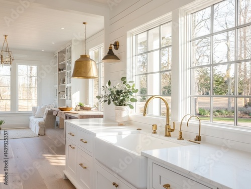 Modern kitchen design with white cabinets, large windows, and stylish fixtures.