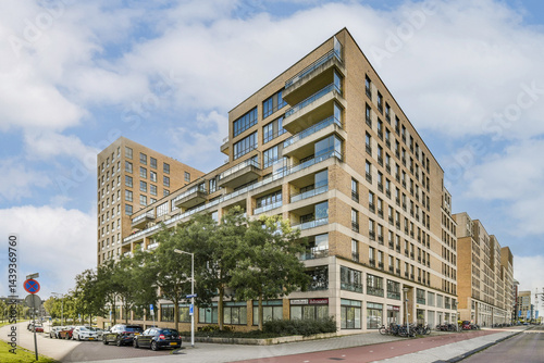 This image showcases a contemporary apartment building featuring balconies, large windows, and modern architectural design, set against a clear blue sky.