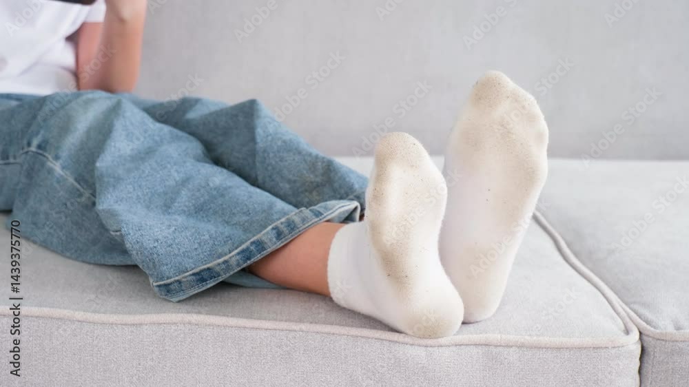 The child has dirty socks. The girl uses a mobile phone