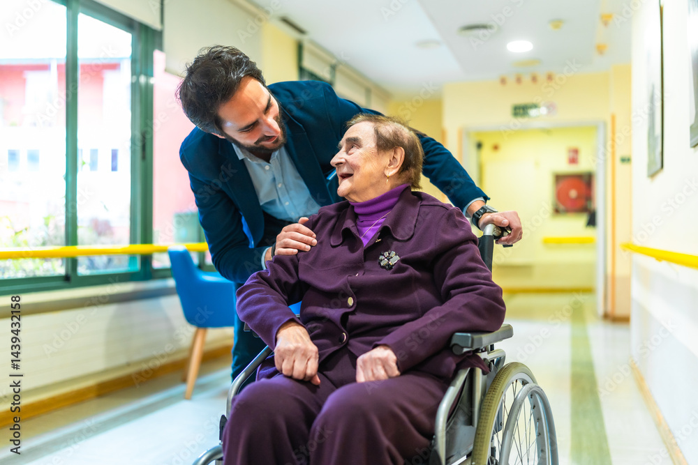Doctor comforting elderly woman in wheelchair at nursing home