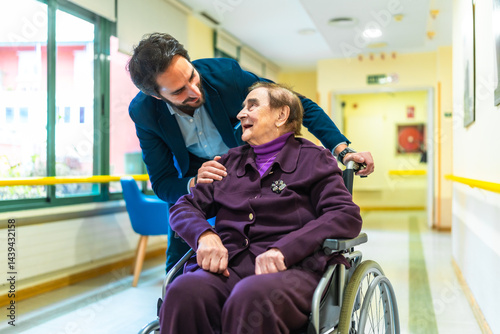 Obraz na płótnie Doctor comforting elderly woman in wheelchair at nursing home w salonie