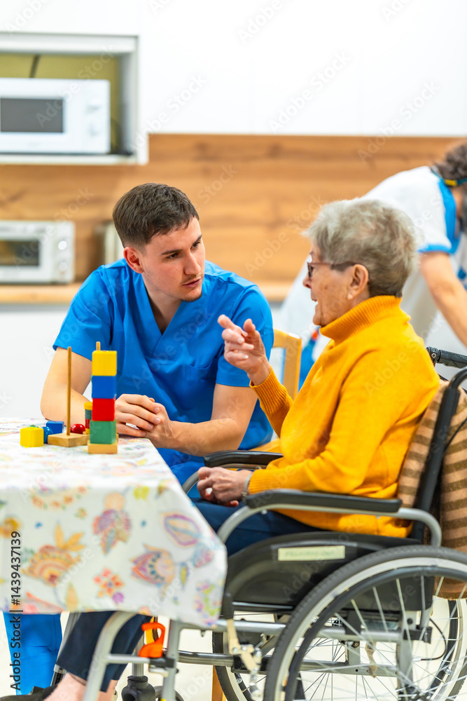 Male nurse assisting elderly woman in wheelchair at nursing home