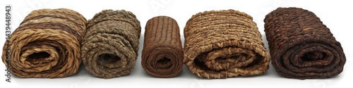 Rolled, woven, natural fiber mats in various shades of brown