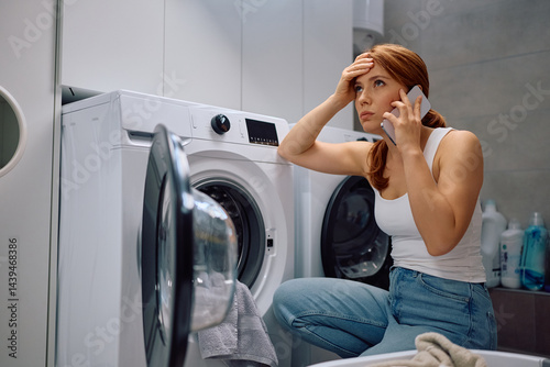 Worried woman calling handyman about washing machine malfunction.