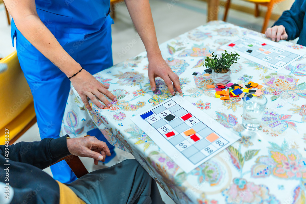 Nurse assisting elderly man playing bingo in nursing home