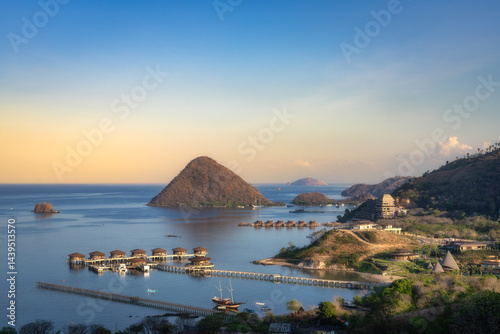 A breathtaking view showcasing tranquil waters, beautiful islands, and luxurious villas, perfectly capturing the essence of an exquisite coastal paradise at sunrise, Labuan Bajo, Komodo, Indonesia