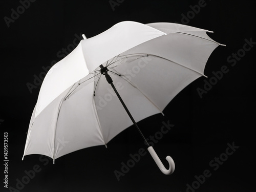 The image of a large, white umbrella with a metal handle in a dark room. 