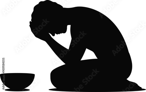 Silhouette of desperate kneeling person beside empty bowl representing poverty and social issues