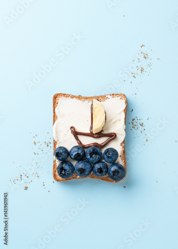 Obraz na płótnie Open sandwich with funny pictures on it. Toast with blueberry and chocolate paste. w salonie