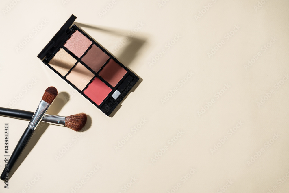 Make up palette and cosmetic brushes at pastel background with hard shadows. Top view image with copy space.