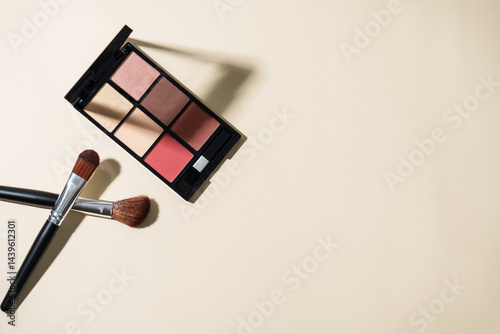 Obraz na płótnie Make up palette and cosmetic brushes at pastel background with hard shadows. Top view image with copy space. w salonie