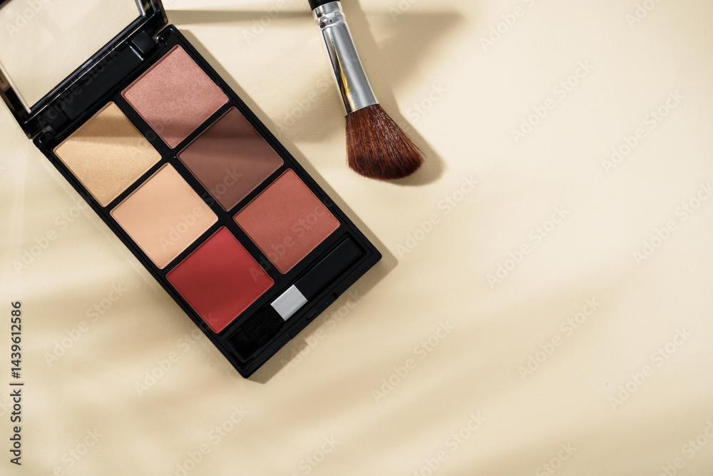 Cosmetic palette and cosmetic brushes at pastel background with shadows. Top view image with copy space.