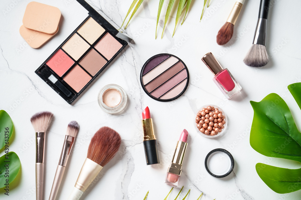 Cosmetic products on white background. Palette, brushes and lipsticks. Top view with copy space.