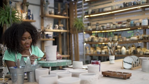 African woman make earth ware at workshop. Small business, hobbies.