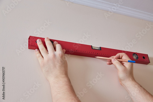 Hands Marking Wall with Level photo